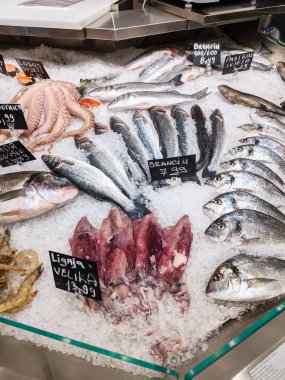 Mürekkep balığı, levrek, somon balığı marketteki tezgahın üzerinde buzun içinde yatıyor. Yüksek kalite fotoğraf