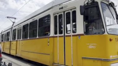 Sarı tramvay Tuna Nehri 'nin kıyısında raylar boyunca ilerliyor. Budapeşte, Macaristan. Yüksek kalite 4k görüntü