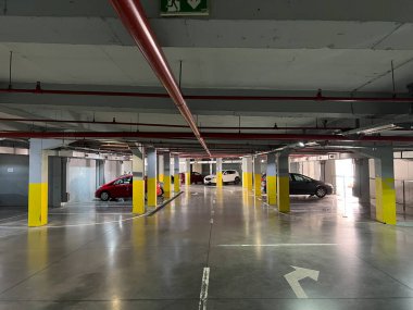 Arabalar büyük bir beton yeraltı otoparkının üzerinde duruyor. Yüksek kalite fotoğraf