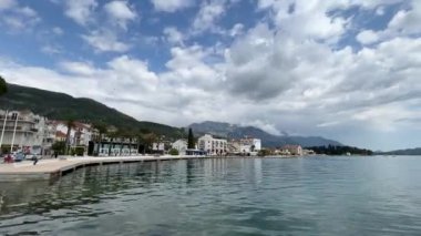 Seashore with beautiful buildings against the backdrop of mountains. Montenegro. High quality FullHD footage