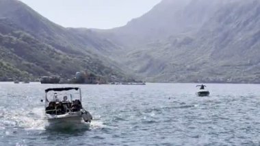 Turistli tekne, dağların arka planına karşı denizde yüzüyor. Yüksek kalite 4k görüntü