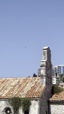 Yolcu uçağı eski kasabanın kırmızı çatıları üzerinde uçar. Yüksek kalite 4k görüntü