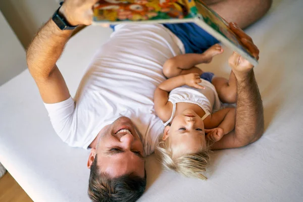 Young Dad Reads Book Little Girl Lying Bed High Quality — Stok Foto