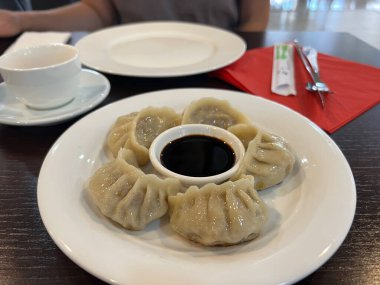 Masada bir tabak jiaozi ve soya sosu var. Yüksek kalite fotoğraf