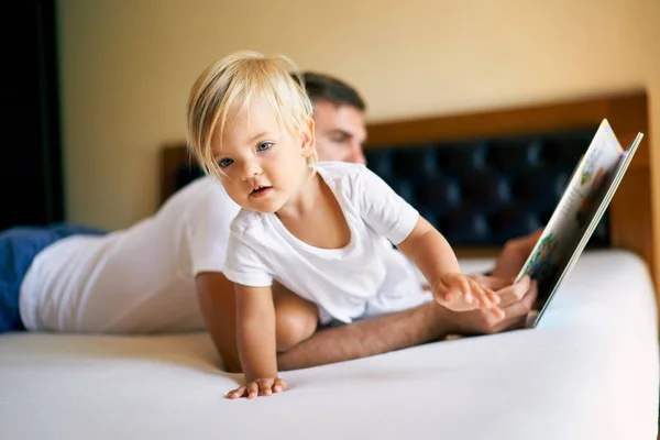 Little Girl Crawling Bed While Dad Reading Book High Quality — Stok Foto