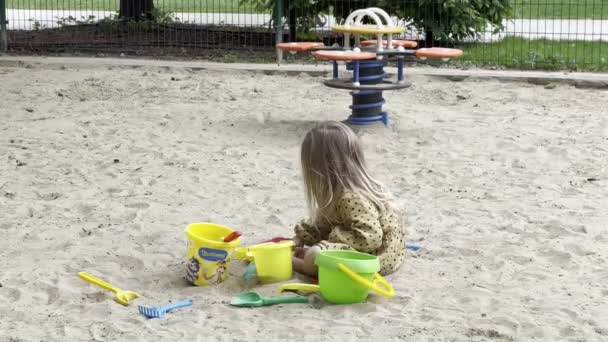 Little Girl Pours Sand Shovel Bucket Sandbox High Quality Footage — Vídeo de Stock