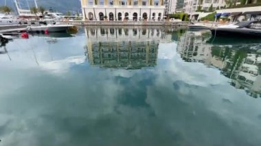 Reflection in the water of the pier near the Regent Hotel. Porto, Montenegro. High quality FullHD footage