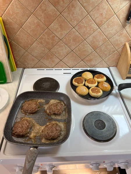 Hamburger patties being fried in a frying pan in the kitchen. High quality photo