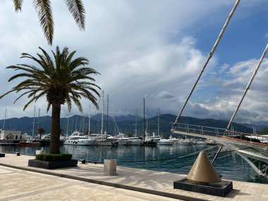 Yachts are moored at the pier against the backdrop of the mountains. Porto, Montenegro. High quality photo