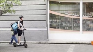 Motosikletli bir kurye yoğun bir kaldırımda geziyor. Yüksek kalite 4k görüntü