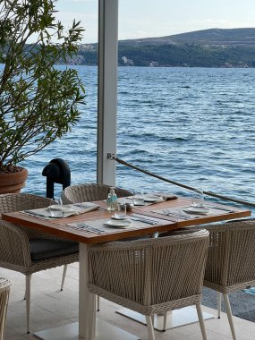Deniz kenarındaki restoran terasında hasır sandalyeli ahşap masa. Yüksek kalite fotoğraf