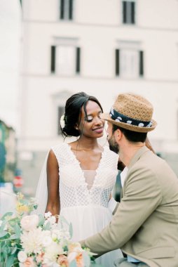 Groom hugs bride on the background of the old building. High quality photo