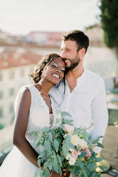 Bride with a bouquet put her head on the shoulder of the groom. High quality photo