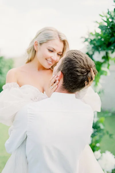 Bride Touches Face Groom Holding Her His Arms Portrait High — Φωτογραφία Αρχείου