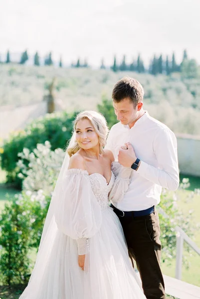 Groom Holds Bride Hand His Chest While Standing Garden High — стокове фото