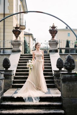 Bride in a long dress on the steps of an old villa. Como. Italy. High quality photo