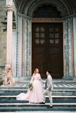 Newlyweds stand on the steps of the church. Bergamo, Italy. High quality photo