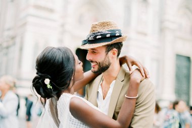 Bride and groom embrace in the square in front of the cathedral in Florence. High quality photo