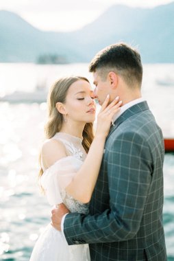 Bride touches the face of the groom embracing her. High quality photo