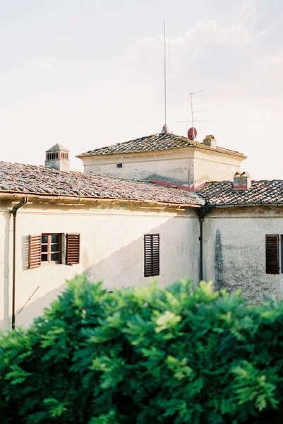 Ancient villa in a green garden against a cloudy sky. High quality photo