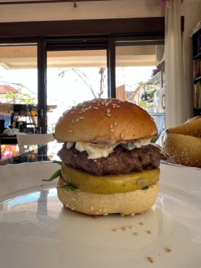 Big hamburger lies on a plate in a cafe. High quality photo