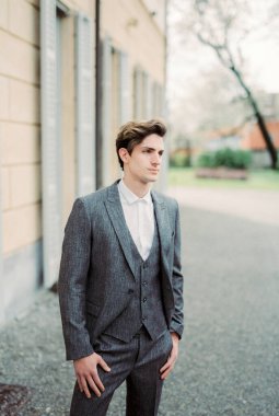 Man in a gray suit stands near an old villa. Como, Italy. High quality photo