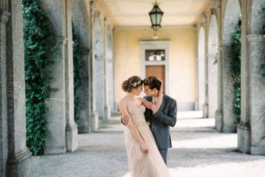 Bride and groom hugging on the terrace of an old villa. Lake Como, Italy. High quality photo