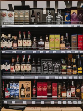 Shelves with different types of whiskey in a supermarket. High quality photo