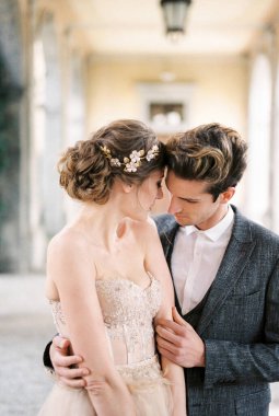 Groom hugs bride on the terrace. Portrait. High quality photo