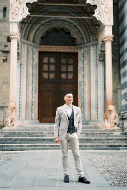 Man in a suit stands in front of the entrance to the church. Bergamo, Italy. High quality photo
