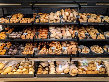 Buns, doughnuts, bagels lie on the shelves in the supermarket. High quality photo