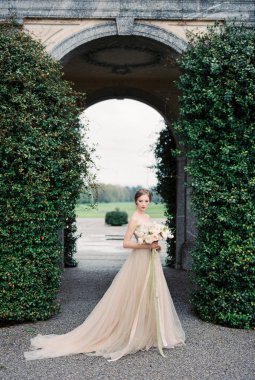 Bride with a bouquet stands near an old villa. Como, Italy. High quality photo