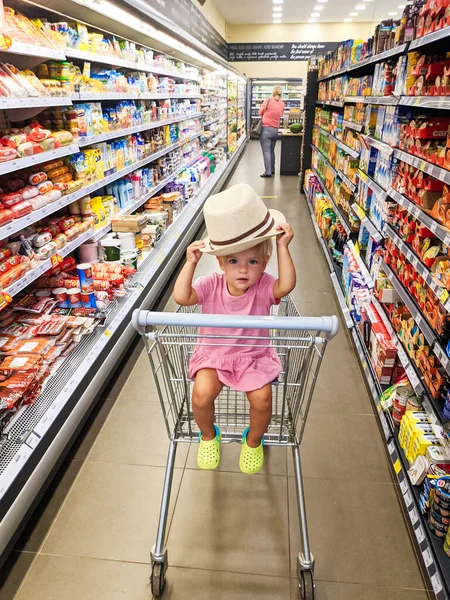 Little Girl Hat Sits Supermarket Cart Rows Groceries High Quality — Stockfoto