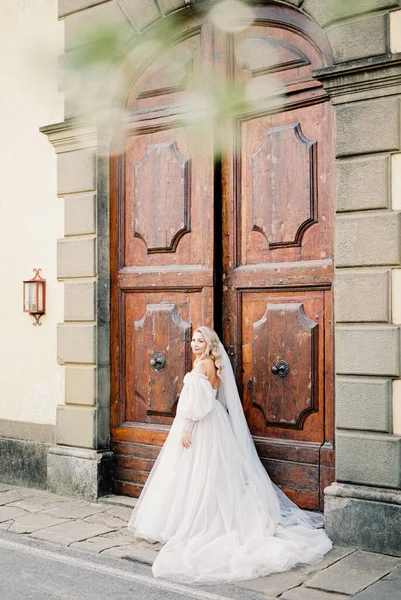 Pengantin Dengan Gaun Putih Dengan Kerudung Berdiri Dekat Pintu Kayu — Stok Foto