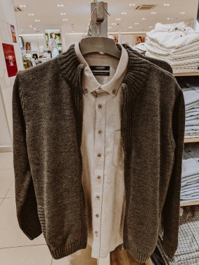 Sweater with a zipper hangs on a shirt on a hanger in a store. High quality photo