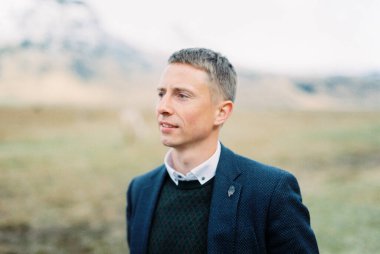 Portrait of a man in a suit in a pasture. Iceland. High quality photo