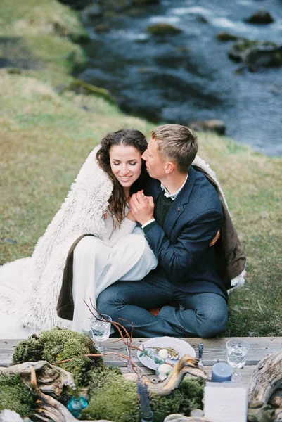 Groom Kisses Bride Blanket Laid Table River Bank High Quality — стоковое фото