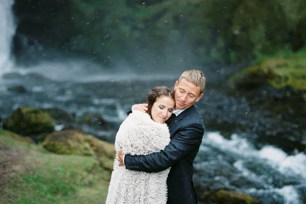 Groom Hugs Bride Falling Snow Waterfall Iceland High Quality Photo — стоковое фото