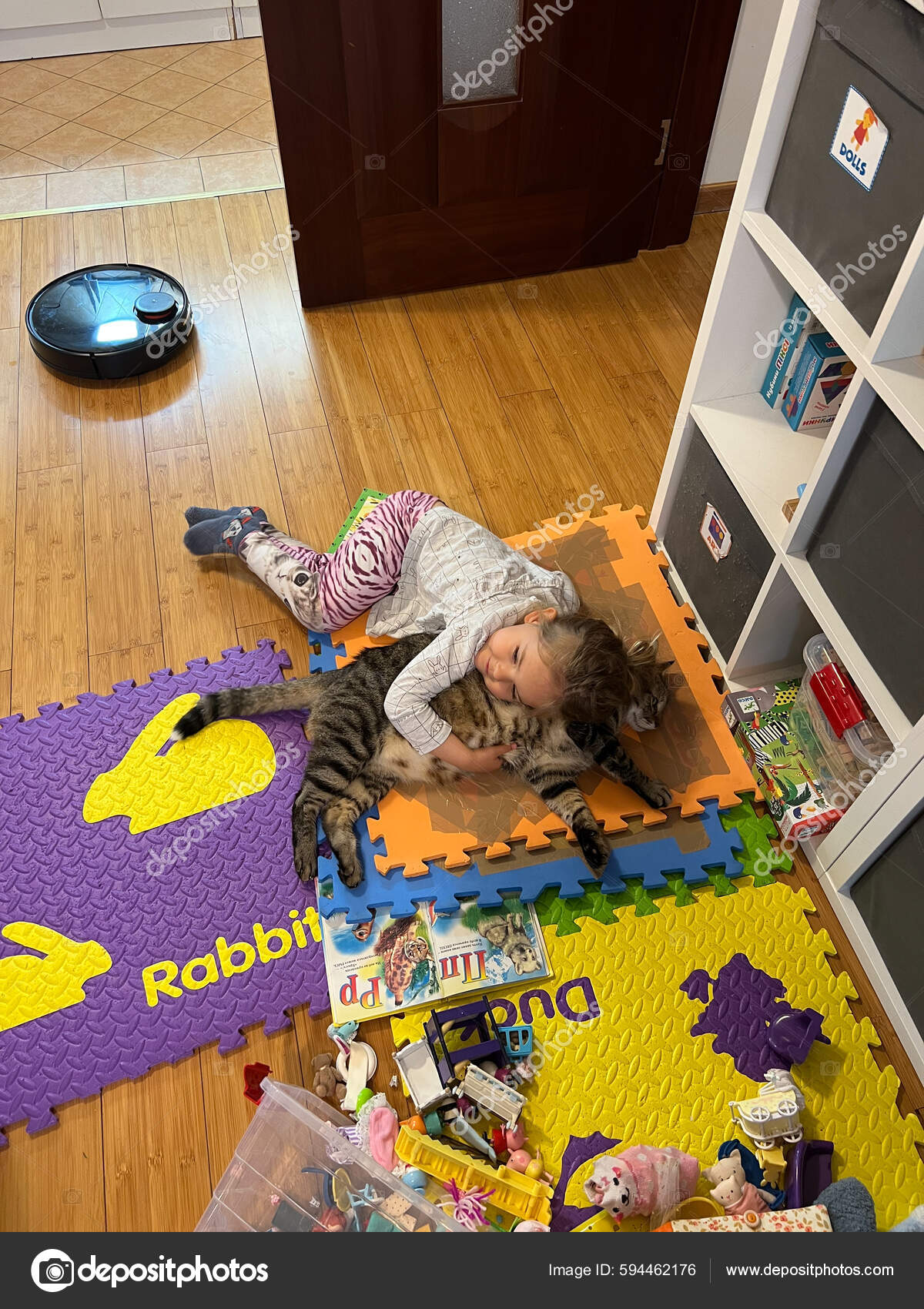 Bebé alegre sorprendido yace boca abajo sobre una alfombra de colores en el  suelo