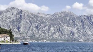 Boat is moored off the coast of Perast against the backdrop of the mountains. High quality 4k footage