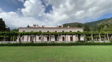 Beautiful house at the foot of green mountains under gray clouds. High quality 4k footage