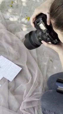 Photographer girl taking pictures of wedding invitations with rings. High quality FullHD footage