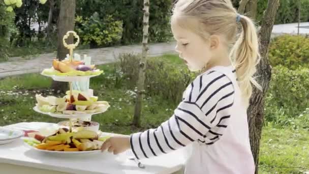 Little Girl Eats Piece Pear Fruit Plate High Quality Footage — Stockvideo