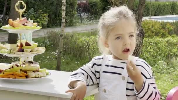 Little Girl Eats Piece Apple Sitting Table High Quality Footage — Stockvideo