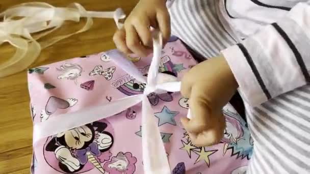 Little Girl Unties Ribbon Gift High Quality Footage — Stockvideo