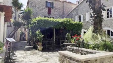 Open-air restaurant in the courtyard of old stone houses. High quality 4k footage