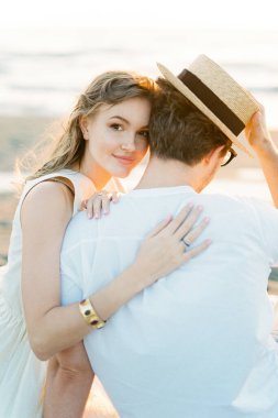 Woman hugging man shoulder on the beach. High quality photo