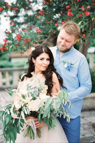 Groom Hugs Bride Bouquet Flowers High Quality Photo — Stockfoto