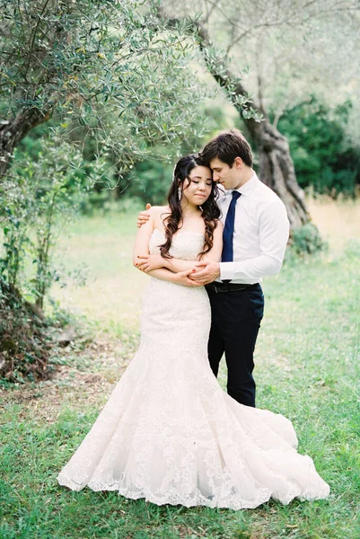 Γαμπρός Αγκαλιάζει Νύφη Ένα Φόρεμα Γοργόνας Που Στέκεται Κάτω Από — Φωτογραφία Αρχείου