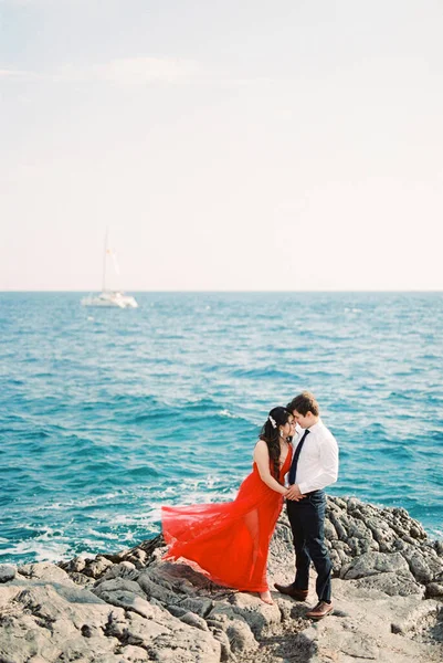 Woman Red Dress Hugs Man Standing Rock Sea High Quality — Stockfoto